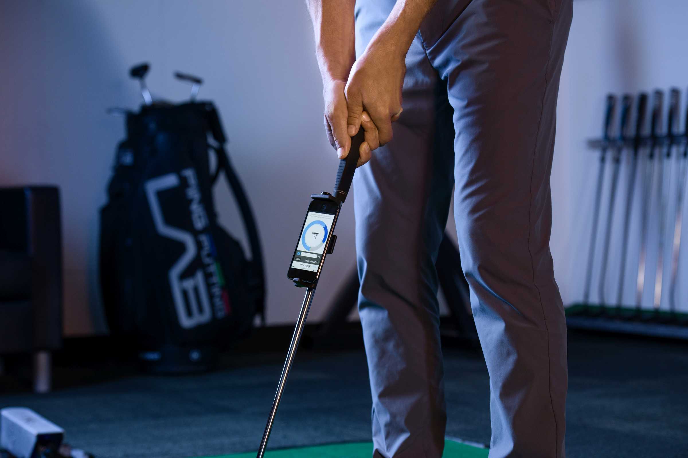 Golfer performing a self-fitting using the PLD iPING app on an Apple iPod attached to his putter