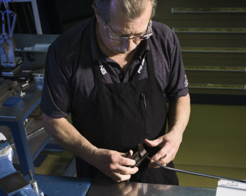 technician assembling putter