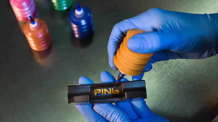 Paint filling the PING logo during the final assembly process