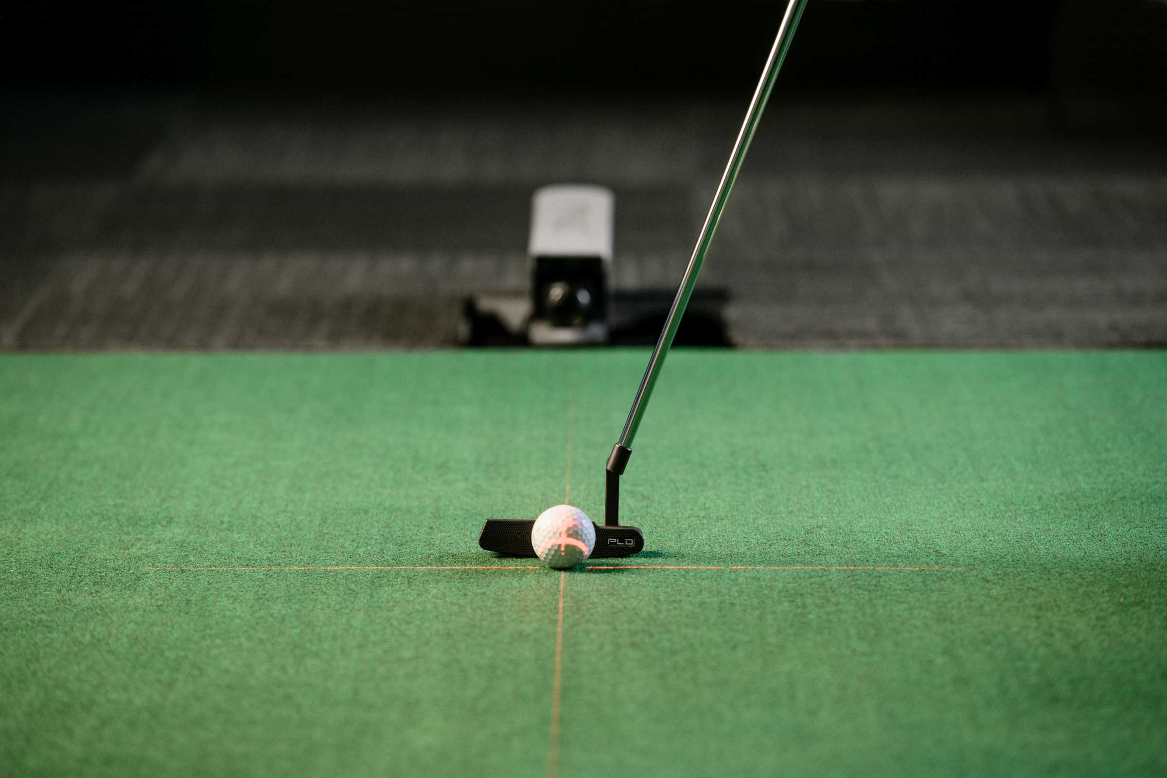 Golfer putting in PLD Lab with alignment lasers